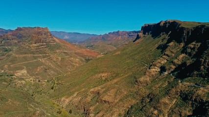 aerial drone image of beautiful stunning landscape view off the Degollada de La Yegua viewpoint with cliff rock peaks and valley with a curvy road on a sunny day