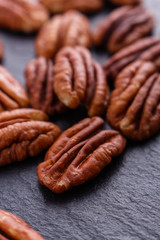 delicious pecan nuts on a dark stone background