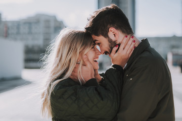 Beautiful young couple feeling happy while touching foreheads