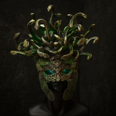 Head Medusa, creature of Greek mythology. pieces made by hand with goldsmiths and metals such as gold and copper. wears a helmet of green and gold snakes