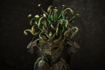 Medusa, creature of Greek mythology. pieces made by hand with goldsmiths and metals such as gold and copper. wears a helmet of green and gold snakes
