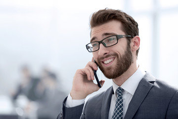 businessman talking on smartphone on office background