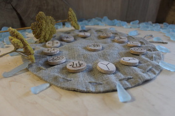Wooden handmade witch runes with a linen pouch, blue cristals and yellow flowers in a rustic style