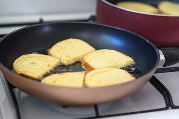 Cooking french toast on frying pan. Close up fried bread in boiling oil on pan.