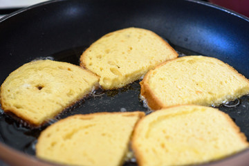 Cooking french toast on frying pan. Close up fried bread in boiling oil on pan.