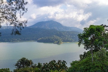Fototapeta na wymiar Lake Buyan,caldera lake at Bali. Beautiful lake with turquoise water in the mountains of the island of Bali. Landscape, lake among mountains, sky, clouds.
