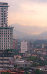 Smog and mist from recent rains create a moody atmosphere in the last light overlooking Kuala Lumpur