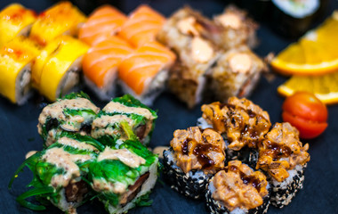 Sushi Set nigiri and sushi rolls on gray stone slate on metal background