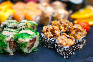 Sushi Set nigiri and sushi rolls on gray stone slate on metal background