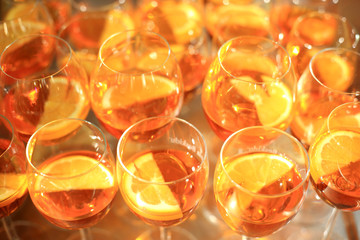Kieliszki pomarańczowego wina z plastrami pomarańczy, lampki z winem. - obrazy, fototapety, plakaty