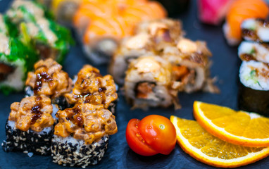 Sushi Set nigiri and sushi rolls on gray stone slate on metal background