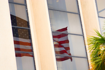 Reflection of american flag on window of a building