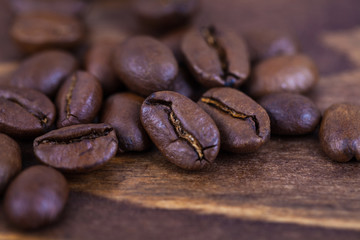 Roasted coffee beens on a wooden table, close up