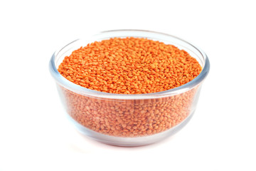 Red lentil in glass bowl isolated on white background