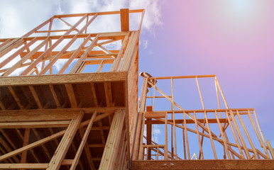 New residential construction house framing against a blue sky.