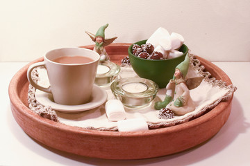 Christmas arrangement with sweets and cocoa. Sweets and marshmallows. Candles and angels. Dessert on a wooden tray.