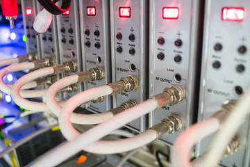 Rack with telecommunication equipment is in the data center server room. Coaxial television cables...