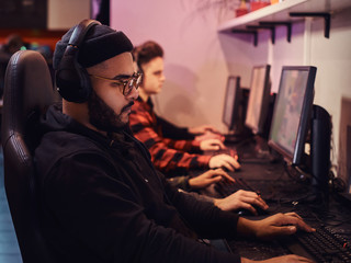 A team of professional cyber sportmans, trains for the championship, plays in a multiplayer video game on pc in a gaming club or internet cafe.