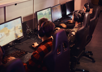 A team of professional cyber sportmans, trains for the championship, plays in a multiplayer video game on pc in a gaming club or internet cafe.