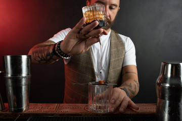 Professional barman mixes cocktails