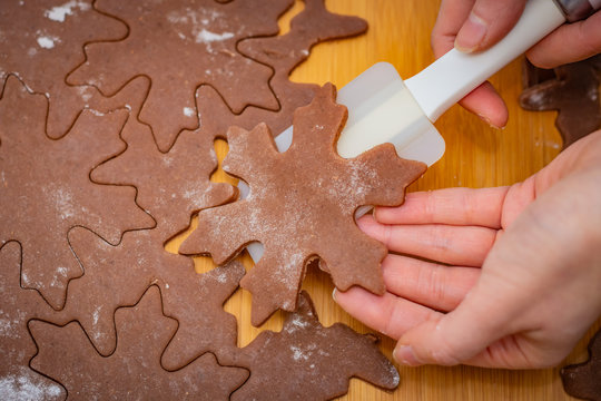 Star-shaped cake is lifted by a woman's hands with a white spatula, the preparation for Christmas pastries