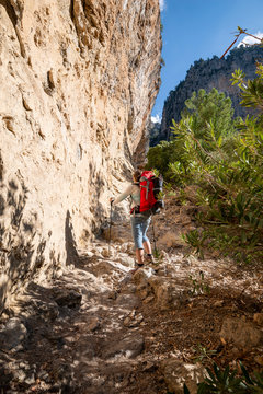 Traveler climbs along narrow mountain gorge