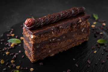 A piece of chocolate cake with biscuit, hazelnut and cocoa filling. Assorted Confectionery Range.