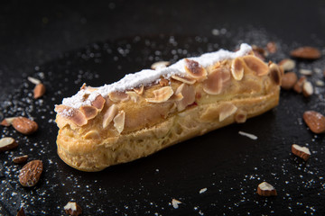 Cake eclair with custard, almonds, chocolate. Assortment of confectionery.