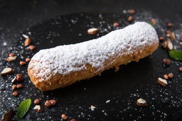 Cake eclair with custard, almonds, chocolate. Assortment of confectionery.