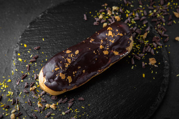 Cake eclair with custard, almonds, chocolate. Assortment of confectionery.
