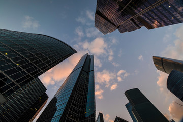 bottom-up view of skyscrapers and flying clouds