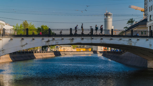 people crossing the city's canal at the hump-backed bridge