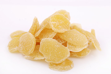 Pieces of dry ginger in sugar on a white background.