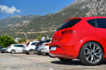 Fototapeta na wymiar red hatchback car parked in row of mountain parking