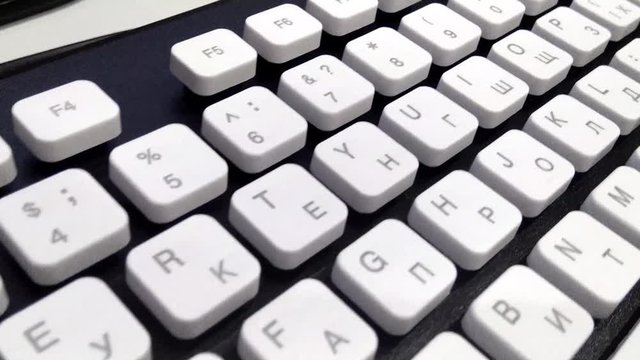 The camera moves from the top over a beautiful trendy black and white keyboard. Close up. Multilingual keyboard layout.