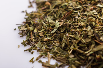 dried tarragon and essential oil on a white background