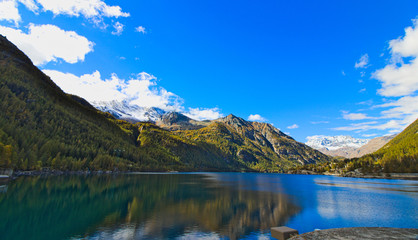Fototapeta na wymiar Lake of Ceresole Reale, near the Nivolet pass, clear autumn morning, blue sky, Piedmont, Italy