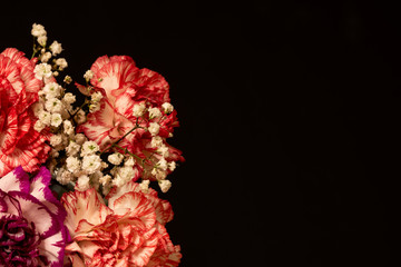 Decorated bouquet of carnations on a dark background with copy space