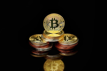 Close-up virtual currency bitcoin on black background. Golden, silver, bronze, bitcoins on black background. Physical Bitcoin. Cryptocurrency trading concept.