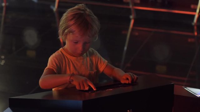 Little boy uses a table pc with an astronomical zodiak map. Children education concept.