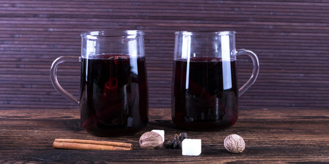 Decorated composition of mulled wine in glasses on wooden table