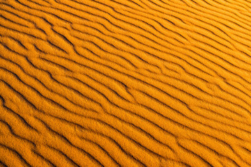 Orange dune waves pattern background of Sahara Desert, Merzouga, Morocco in Africa