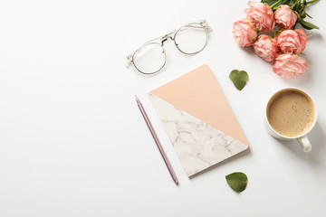 Flat lay composition with book, flowers and cup of coffee on white background. Space for text