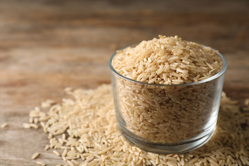 Brown rice in glass on table. Space for text