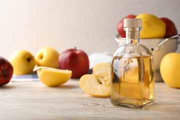 Composition with bottle of apple vinegar on table. Space for text