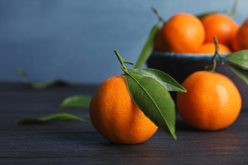 Fresh ripe tangerines with green leaves on table. Space for text