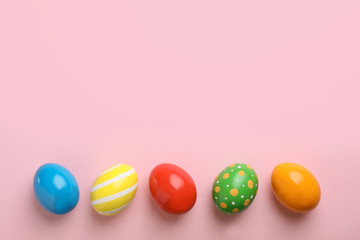 Fototapeta na wymiar Decorated Easter eggs and space for text on color background, top view