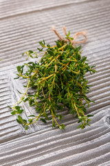essential oil of thyme on a gray wooden rustic background