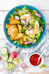 Delicious baked potato, boiled egg and fresh vegetable salad of lettuce, cucumber and radish. Summer menu for detox diet