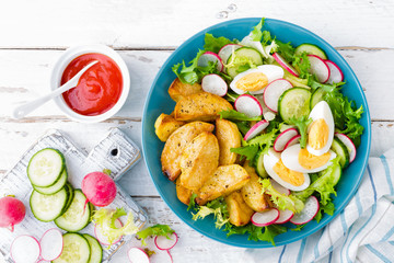 Delicious baked potato, boiled egg and fresh vegetable salad of lettuce, cucumber and radish. Summer menu for detox diet